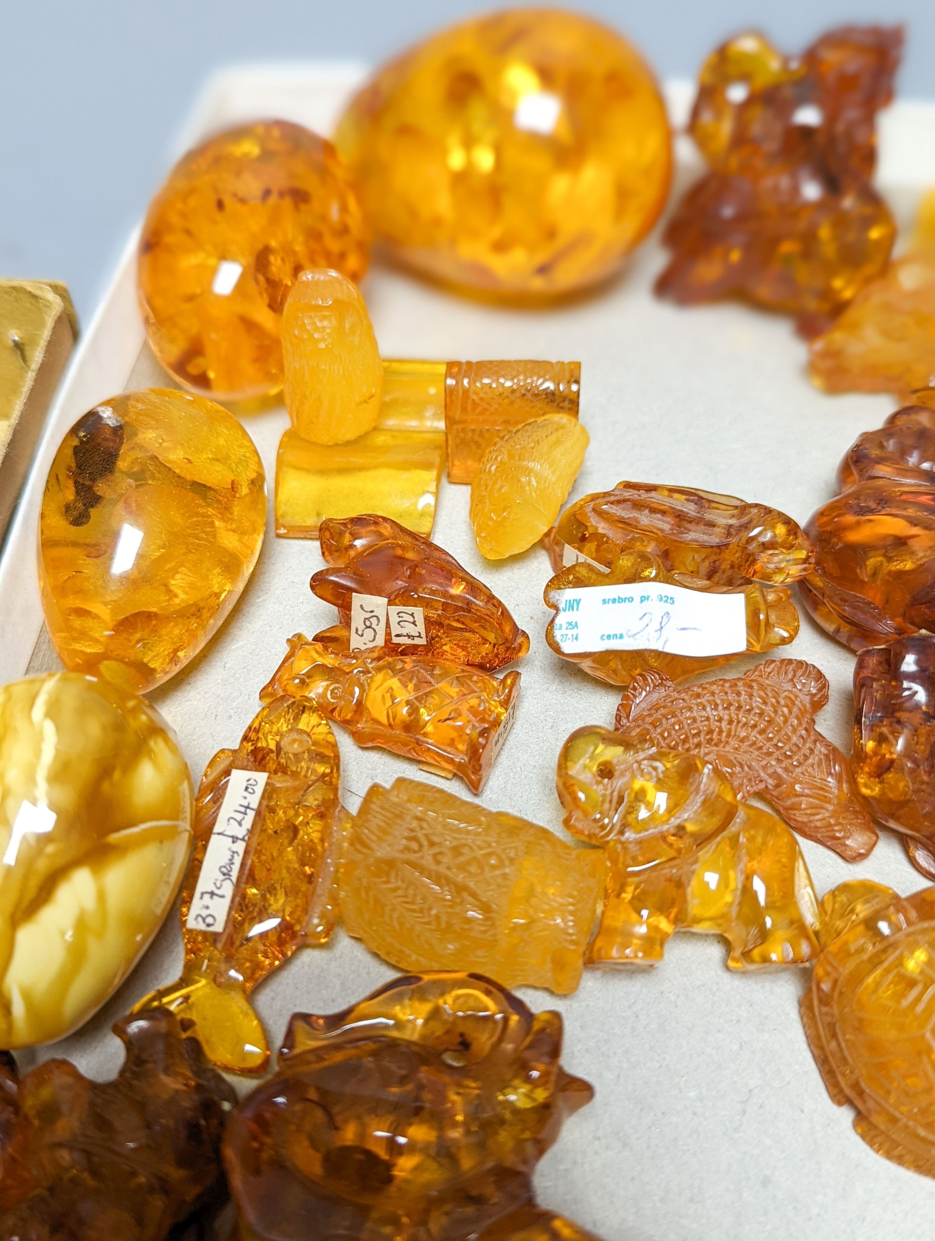 A mixed collection small carved amber wares including dice, eggs and cigarette holders, etc.